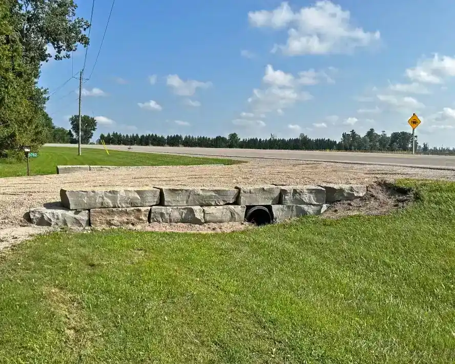 Driveway entrance with large armour stone retaining wall built by Armour Designs in rural Ontario.