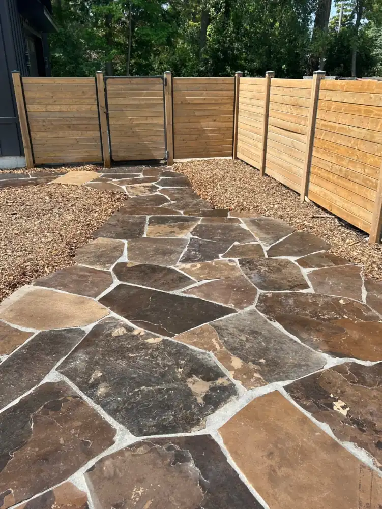 Natural flagstone walkway installed by Armour Designs as part of a custom landscape project.