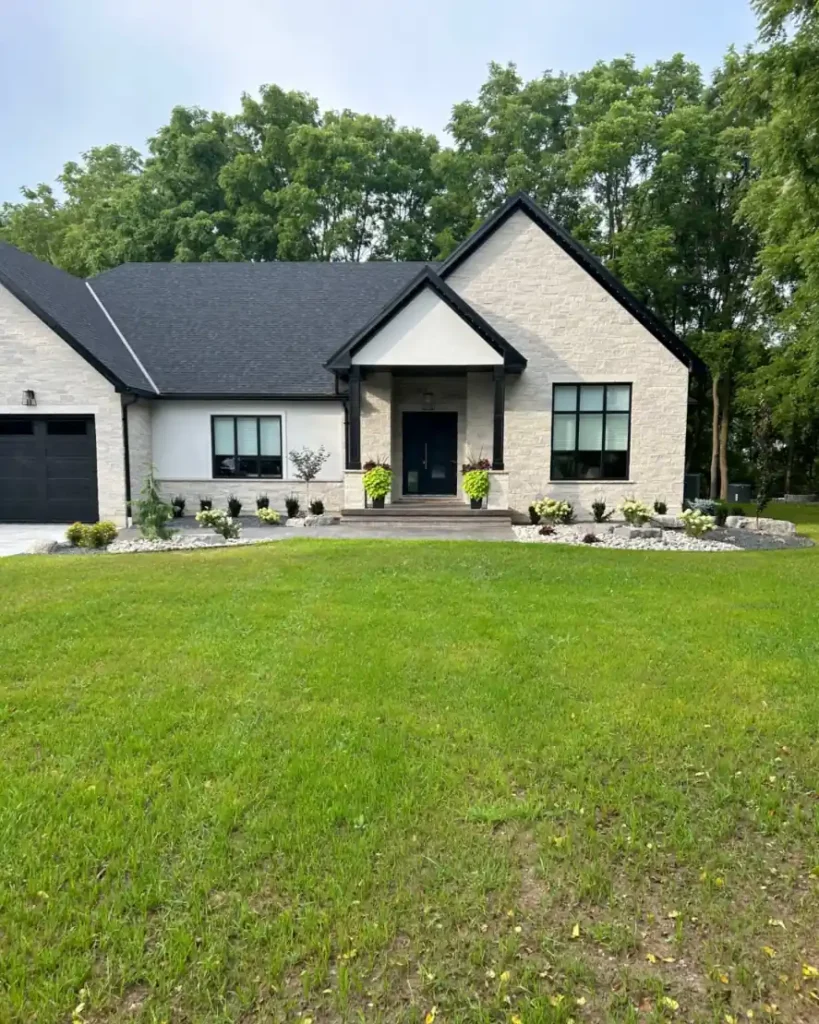 Front yard landscaping with fresh plantings, rock beds, and walkway installed by Armour Designs in Ailsa Craig.