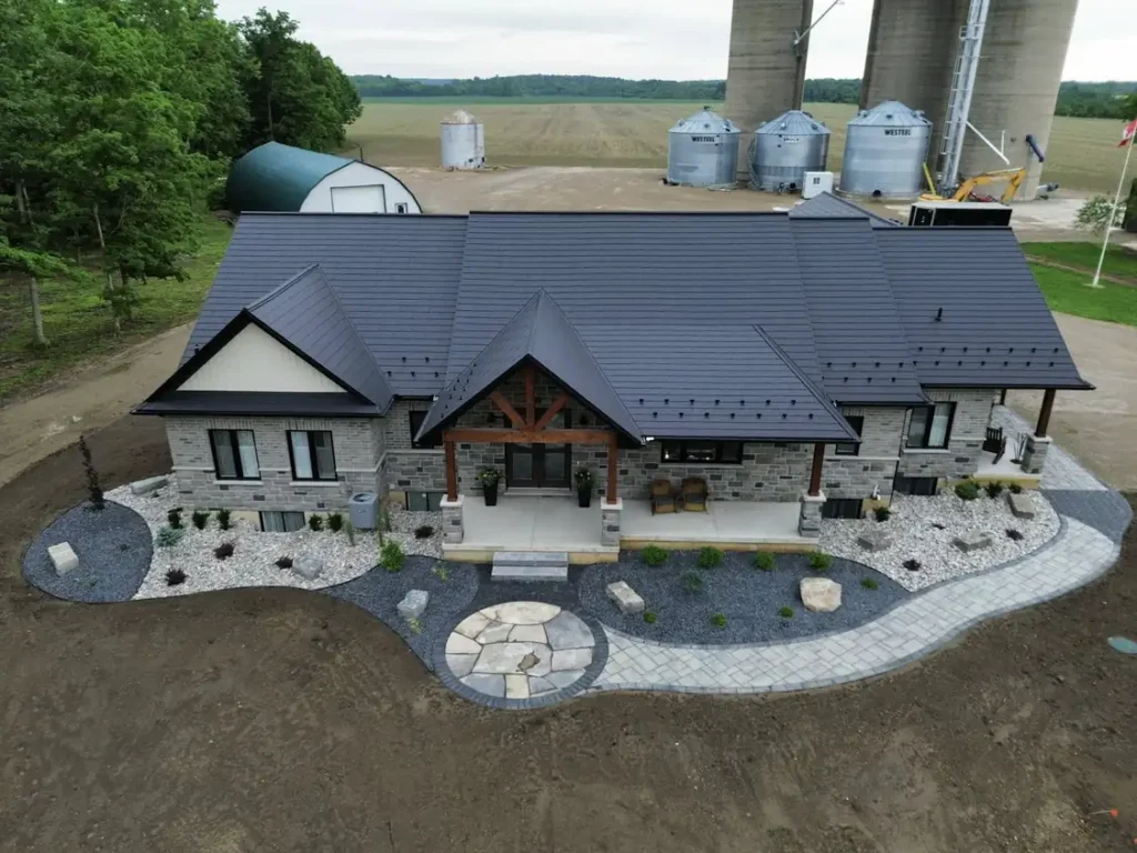 Aerial front yard landscape remodel with stone edging, rock garden beds, and new walkway by Armour Designs.