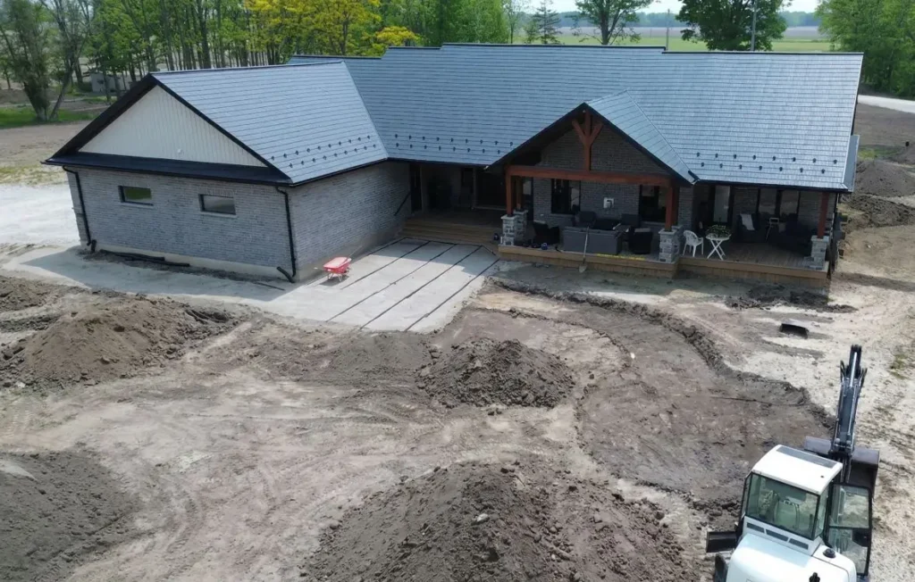 Backyard excavation and grading work preparing for patio and walkway installation with equipment on site