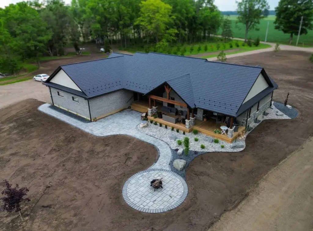 Backyard patio and curved interlock walkway with covered seating area at a rural Ontario home