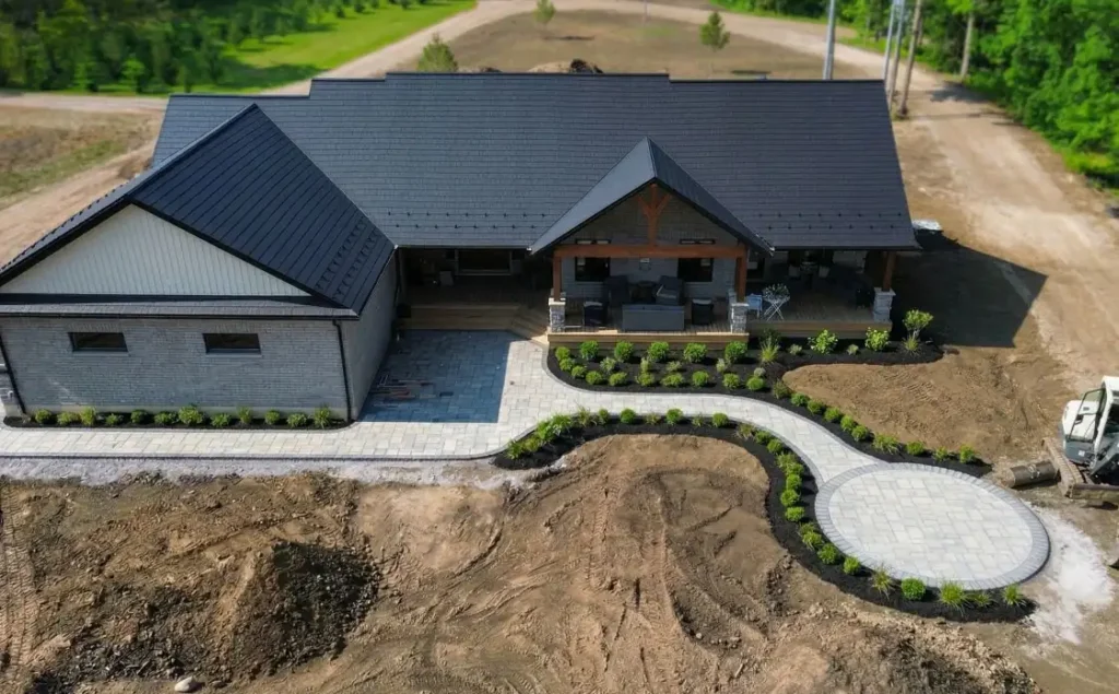 Interlock front walkway and landscaped entryway at a rural Ontario home with stone and gravel features