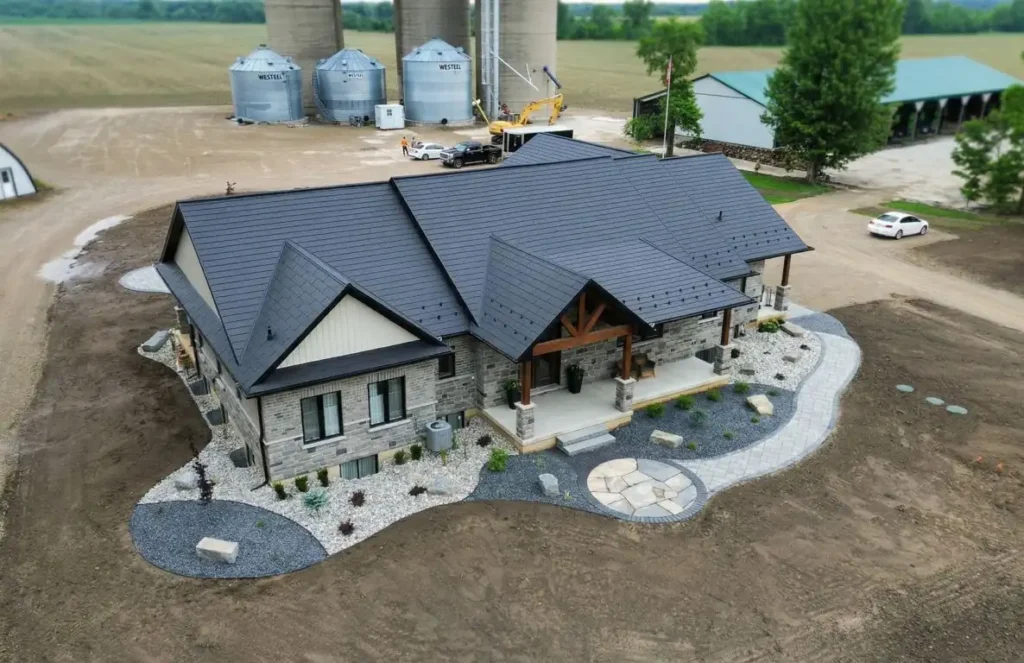 Curved interlock walkway with landscaping beds and stone features at a rural Ontario home